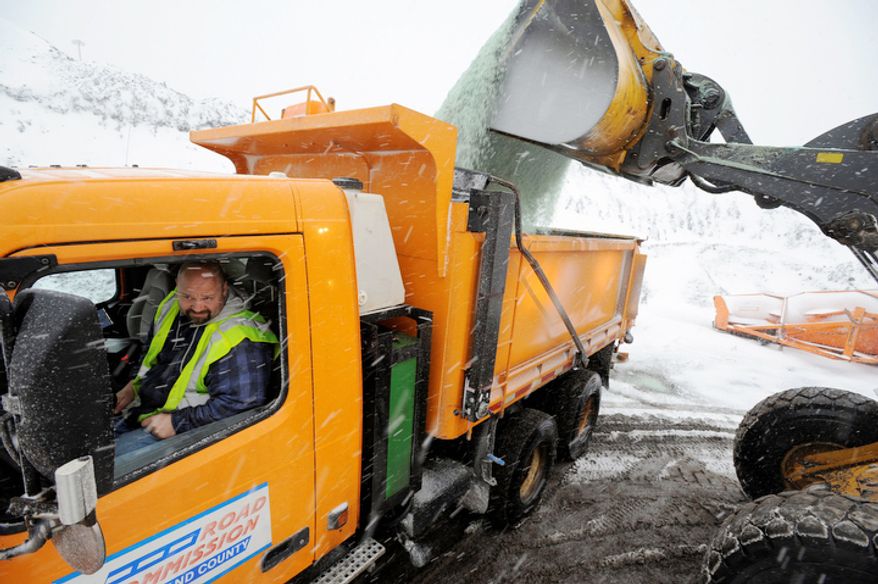 Driver Neil Simmons keeps an eye on the load as his trucks is loaded up with salt at the Oakland County Road Commission maintenance yard in Southfield, Mich., Wednesday afternoon, Dec. 26, 2012. (AP Photo/The Detroit News, David Guralnick)