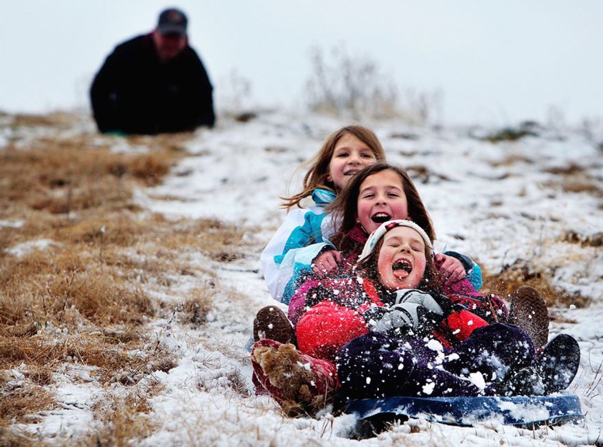 Elizabeth Seymour, 9, front, gets a mouthful of snow while sledding at the Colllierville, Tenn., landfill with Carly Catanzaro, 10, and her sister Ellery Seymour, 10, back, Wednesday Dec. 26, 2012. Shelby county managed to avoid the heavy snow that blanketed much of Arkansas, but that didn't stop the trio of sledders from taking advantage of the popular hill. (AP Photo/The Commercial Appeal, Jim Weber)