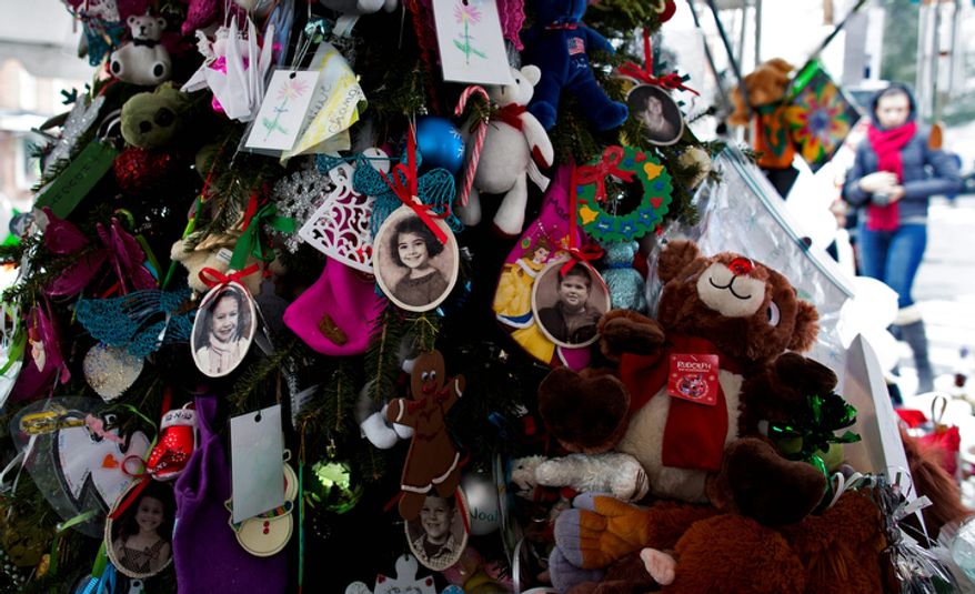 Portraits of slain students and teachers hang from a tree at a memorial in Newtown, Conn. Tuesday, Dec. 25, 2012. People continue to visit memorials in the wake of the shootings after gunman Adam Lanza walked into Sandy Hook Elementary School in Newtown, Conn., Dec. 14, and opened fire, killing 26, including 20 children, before killing himself. (AP Photo/Craig Ruttle)