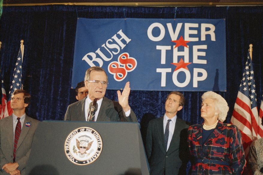 Vice President George H. W. Bush, second from left, with his wife Barbara Bush, looking on at right, addresses supporters during an Over the Top rally, Tuesday, May 4, 1988, Washington, D.C. Bush, who clinched the Republican presidential nomination last week, waited until Tuesday to celebrate his success and wins in uncontested Indiana, Ohio and the District of Columbia primary races. Bush's son, George W. Bush is second from right. The man on the left is unidentified. (AP Photo/Charles Tasnadi)