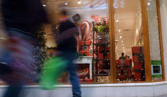 Christmas shoppers walk past a store at a mall in Salem, N.H., on Friday, Dec. 21, 2012. (AP Photo/Elise Amendola)