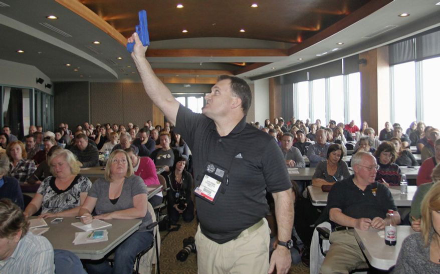 Clark Aposhian, president of Utah Shooting Sport Council, demonstrates with a plastic gun Dec. 27, 2012, during concealed-weapons training for 200 Utah teachers in West Valley City, Utah. The Utah Shooting Sports Council offered six hours of training in handling concealed weapons in the latest effort to arm teachers to confront school assailants. (Associated Press)