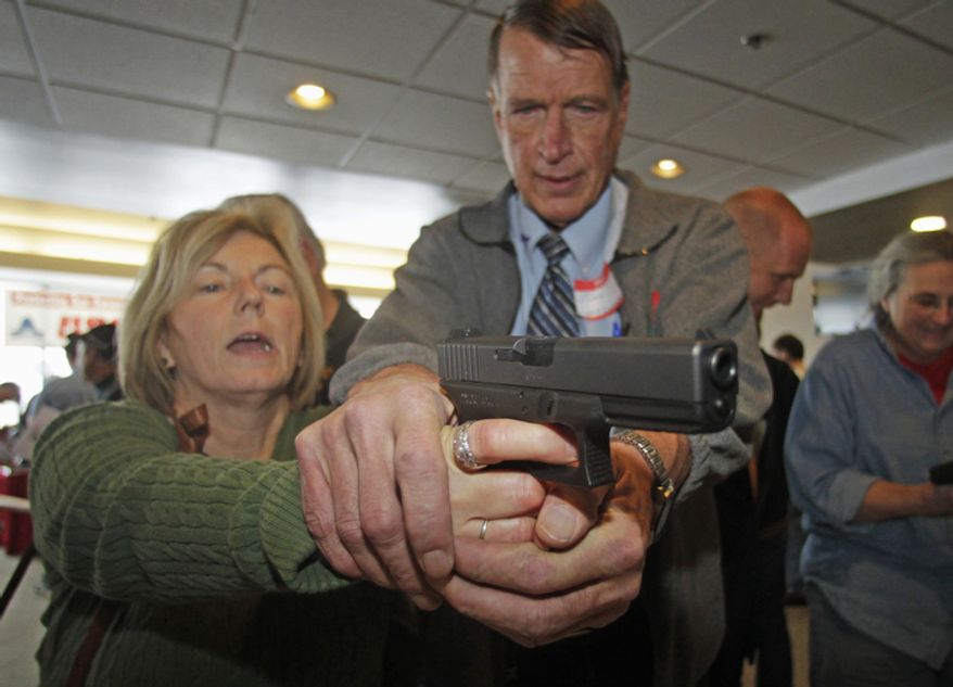 Christine Caldwell (left) receives firearms training with a 9mm Glock from personal defense instructor Jim McCarthy on Dec. 27, 2012, during concealed-weapons training for 200 Utah teachers in West Valley City, Utah. The Utah Shooting Sports Council offered six hours of training in handling concealed weapons in the latest effort to arm teachers to confront school assailants. (Associated Press)