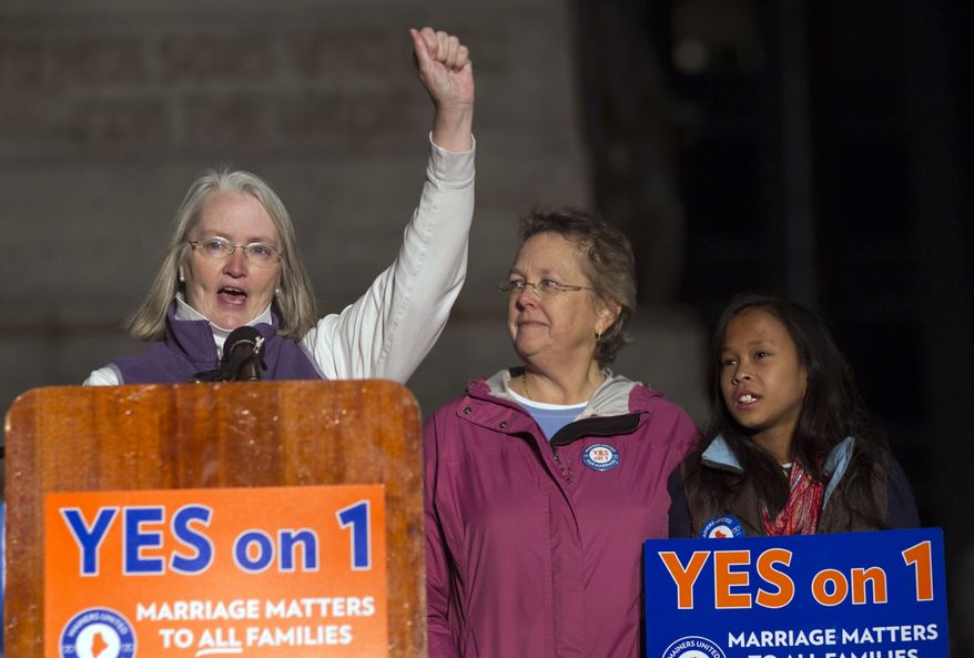 **FILE** Sarah Dowling (left) speaks Nov. 1, 2012, at a gay-marriage rally in Portland, Maine, accompanied by Linda Wolfe, her partner of 18 years, and their daughter, Maya Dowling-Wolfe. Dowling and Wolfe plan to marry after Maine passed a law allowing same-sex marriage, which takes effect at 12:01 a.m., Dec. 29, 2012. (Associated Press)