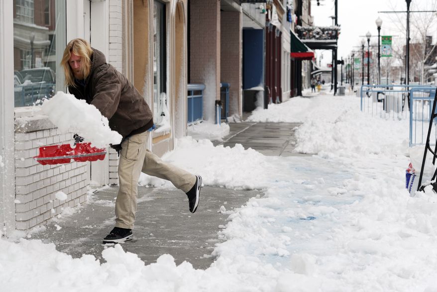 Scott Becker shovels the sidewalks of businesses along Main Street in downtown Evansville, Ind., on Dec. 27, 2012. (Associated Press/The Evansville Courier & Press)