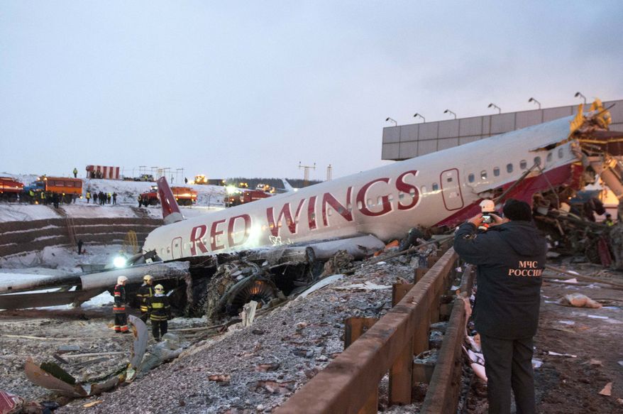 Rescuers work at the site where a plane careered off the runway at Vnukovo Airport in Moscow, Saturday, Dec. 29, 2012. A Tu-204 aircraft belonging to Russian airline Red Wings careered off the runway at Russia's third-busiest airport on Saturday, broke into pieces and caught fire, killing several people. (AP Photo/Alexander Usoltsev)
