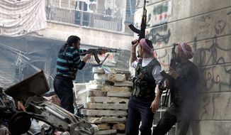 Free Syrian Army fighters fire at enemy positions during clashes with government forces in the Salaheddine district of Aleppo on Saturday. A U.N. envoy warns 100,000 Syrians could be killed next year if fighting continues. (Associated Press)
