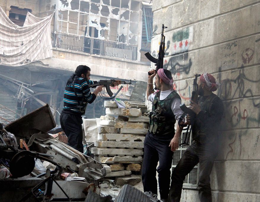 Free Syrian Army fighters fire at enemy positions during clashes with government forces in the Salaheddine district of Aleppo on Saturday. A U.N. envoy warns 100,000 Syrians could be killed next year if fighting continues. (Associated Press)