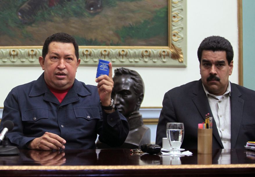 ** FILE ** Venezuelan President Hugo Chavez (left) holds up a copy of the Venezuelan Constitution as Vice President Nicolas Maduro looks on during a televised speech at the Miraflores presidential palace in Caracas, Venezuela, on Saturday, Dec. 8, 2012. (AP Photo/Miraflores Press Office, Marcelo Garcia)
