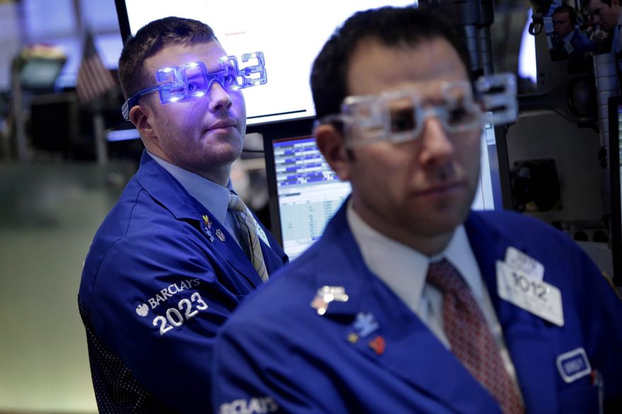 Traders wear "2013" glasses as they work on the floor at the New York Stock Exchange in New York, Monday, Dec. 31, 2012. The stock market struggled for direction Monday morning after five days of losses, with the "fiscal cliff" just hours away and lawmakers yet to reach a solution. (AP Photo/Seth Wenig)