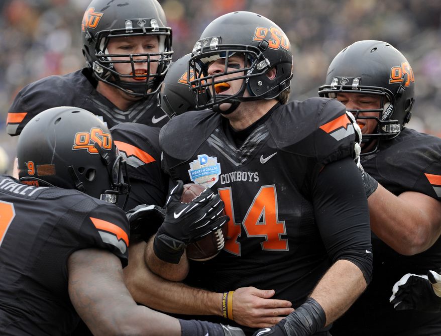 Oklahoma State tight end Jeremy Seaton (44) celebrates with teammates after a first-half touchdown against Purdue during the Heart of Dallas Bowl NCAA college football game, Tuesday, Jan. 1, 2013, in Dallas. (AP Photo/Matt Strasen)