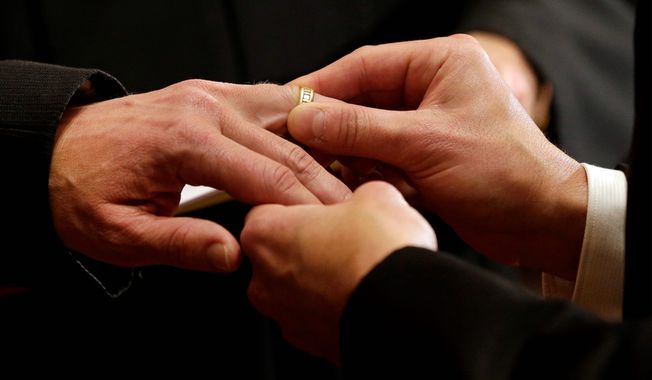 Thomas Rabe, right, places a wedding ring on Robert Coffman&#x27;s finger during a marriage ceremony at City Hall in Baltimore, Tuesday, Jan. 1, 2013. (AP Photo/Patrick Semansky) ** FILE **