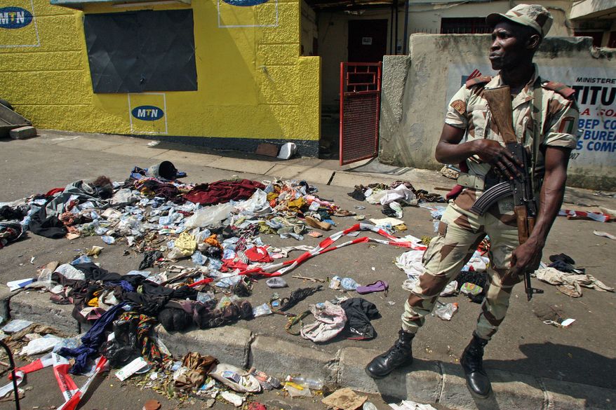 An Ivory Coast soldier stands next to the belongings of people involved in a deadly stampede in Abidjan, Ivory Coast, early on Tuesday, Jan. 1, 2013. At least 61 people were killed following a New Year's fireworks display, and the death toll is expected to rise, officials said. (AP Photo/Emanuel Ekra)