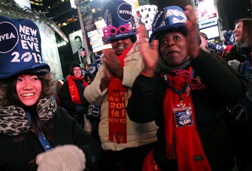 Yayoi Okayama, from Japan, left, Ziporah Choice, from New Jersey, foreground right, and others take part in the New Year's Eve festivities in New York's Times Square on Monday, Dec. 31, 2012. (AP Photo/Tina Fineberg)