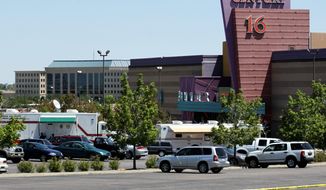 ** FILE ** Emergency vehicles remain at the Century 16 movie theater in Aurora, Colo., on July 21, 2012, after 12 people were fatally shot in the theater. (Associated Press)