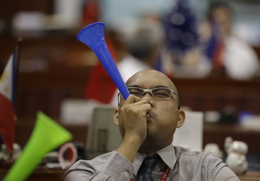 A Filipino trader blows a horn during the first day of trading at Philippine Stock Exchange at the financial district of Makati, south of Manila, Philippines on Wednesday, Jan. 2, 2013. Stock markets in Asia registered relief Wednesday over the U.S. congressional vote to stop hundreds of billions of dollars in automatic tax increases and spending cuts that risked plunging the world's biggest economy into recession. (AP Photo/Aaron Favila)