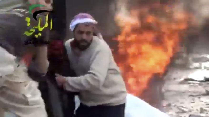 A wounded man is pulled from the site of a Syrian government airstrike on a gas station in the eastern Damascus suburb of Mleiha, Syria, on Wednesday, Jan. 2, 2013. This citizen-journalist image was taken from video that was authenticated based on its contents and other AP reporting. (AP Photo/Shaam News Network via AP video)