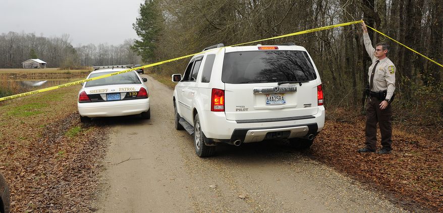 A Walker County sheriff's deputy lifts crime-scene tape for investigators on Wednesday, Jan. 2, 2013, as National Transportation Safety Board officials continue to investigate the fatal crash Tuesday night of a small plane that was reported stolen near Jasper, Ala. (AP Photo/AL.com, Joe Songer)