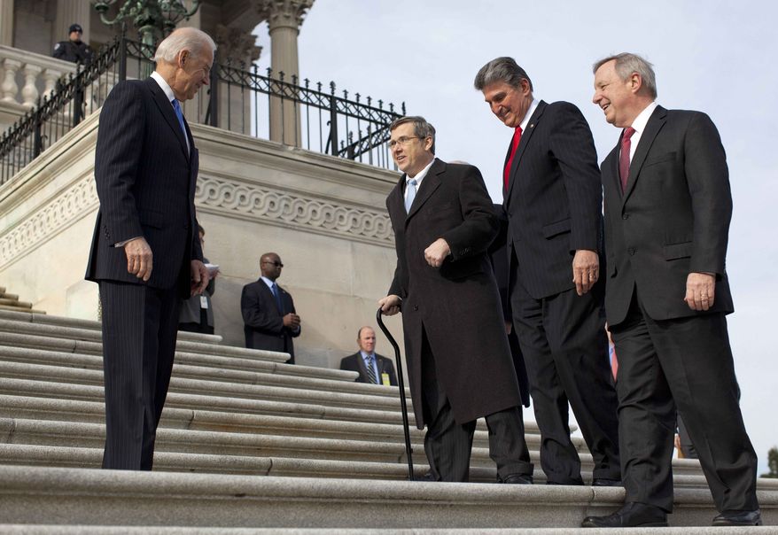 Vice President Joseph R. Biden watches at left as Sen. Mark Kirk, R-Ill., second from left, accompanied by Sen. Joe Manchin, D-W.Va., second form right, and Senate Majority whip Richard Durbin of Ill., right, walks the steps to the Senate door of the Capitol building on Capitol Hill in Washington, Thursday, Jan. 3, 2013. (AP Photo/ Evan Vucci)