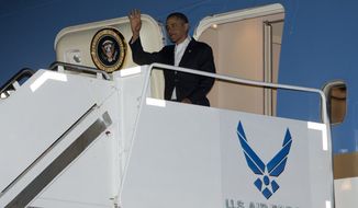 President Obama waves as he deplanes from Air Force One upon his arrival at Joint Base Pearl Harbor-Hickam in Honolulu, Hawaii, on Wednesday, Jan. 2, 2013. The president is back in Hawaii for vacation after a tense, end-of-the-new-year standoff with Congress over the &quot;fiscal cliff.&quot; (AP Photo/Carolyn Kaster)