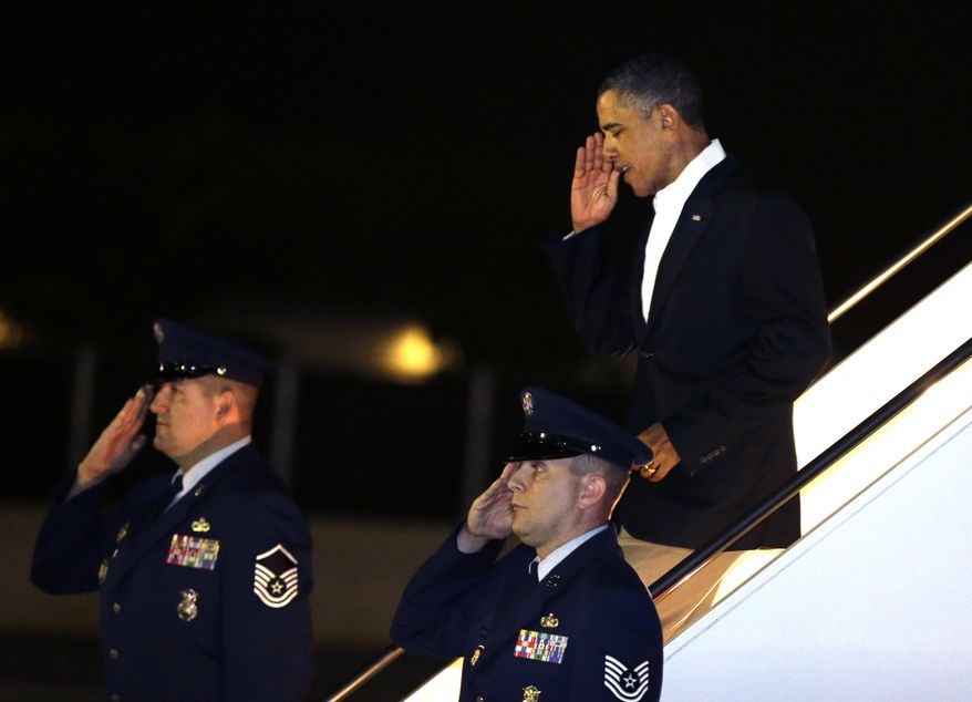President Obama salutes as he deplanes from Air Force One upon his arrival at Joint Base Pearl Harbor-Hickam in Honolulu on Wednesday, Jan. 2, 2013. The president is back in Hawaii for vacation after a tense, end-of-the-new-year standoff with Congress over the "fiscal cliff." (AP Photo/Gerald Herbert)