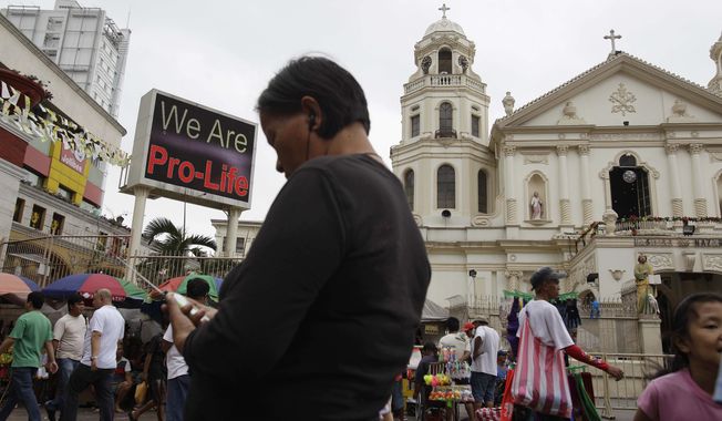 A &quot;Pro-Life&quot; message flashes on an electric signboard outside the Roman Catholic Minor Basilica of the Black Nazarene in downtown Manila on Thursday, Jan. 3, 2013. (AP Photo/Aaron Favila)