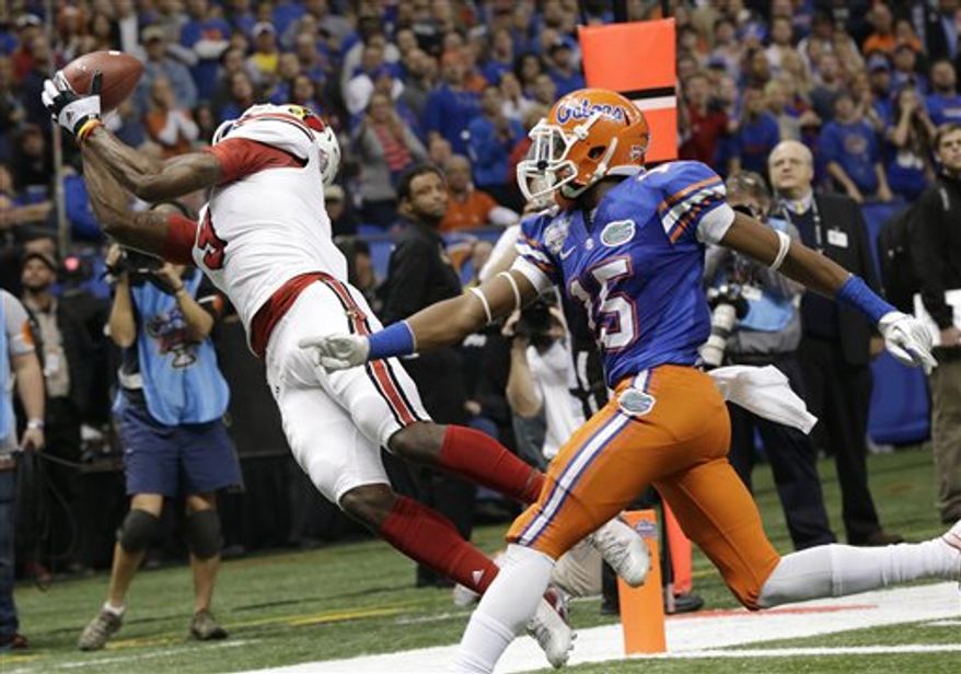 Louisville wide receiver DeVante Parker (9) catches a touchdown pass as Florida defensive back Loucheiz Purifoy (15) defends in the first half of the Sugar Bowl college football game Wednesday, Jan. 2, 2013, in New Orleans. (AP Photo/Dave Martin)