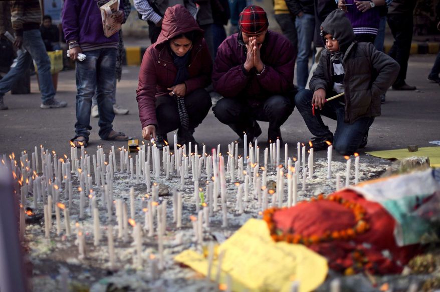An Indian family lights candles in memory of a gang-rape victim in New Delhi, India, Saturday, Jan. 5, 2013. Passers-by refused to stop to help a naked, bleeding gang-rape victim after she was dumped from a bus onto a New Delhi street, and police delayed taking her to a hospital for 30 minutes, the woman's male companion said in an interview. (AP Photo/Altaf Qadri)