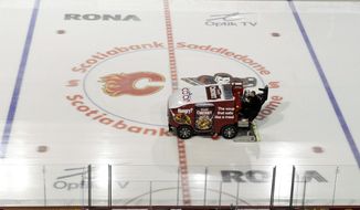 A Zamboni clears the ice at Scotiabank Saddledome, home of the Calgary Flames, on Sunday, the same day a tentative deal was reached to end the lockout. Note, this driver is not Steven James Anderson. (Associated Press) ** FILE **