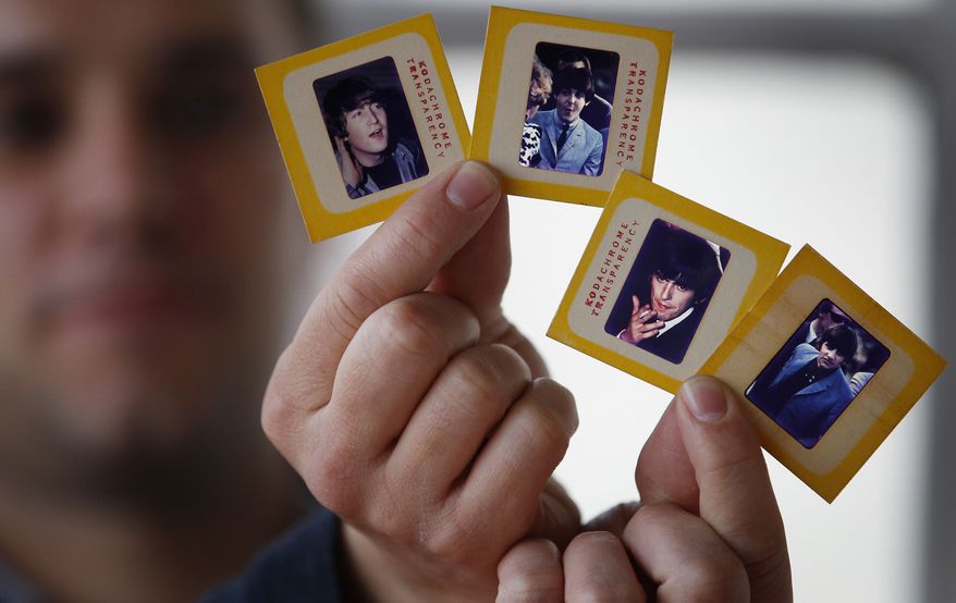 Auctioneer Paul Fairweather holds four color transparencies of the Beatles taken during their first tour of the United States in 1964. The rare images, taken by Dr. Robert Beck, are to be sold along with the copyright at Omega Auctions in Stockport, England, in a special Beatles memorabilia auction in March. The unpublished collection of 65 slides contains many stage shots. (AP Photo/PA, Dave Thompson)