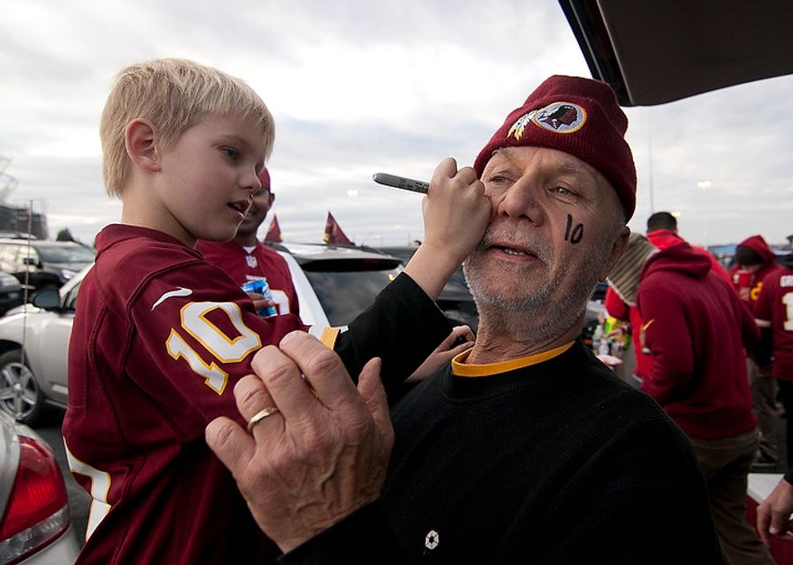 Walter Novak, 68, from Eastern Shores, Md. has his grandson Dominic Jr., 9, write RGIII on his forehead with sharpie in preparation for the Redskins NFC wild card game against the Seattle Seahawks, outside of FedEx Field in Landover Md., on Sunday, January 6, 2013. Walter became a Redskins fan when he was 6 years old at Griffith Stadium and has been passing down his fanhood to his son and now his grandson. (Craig Bisacre/The Washington Times)