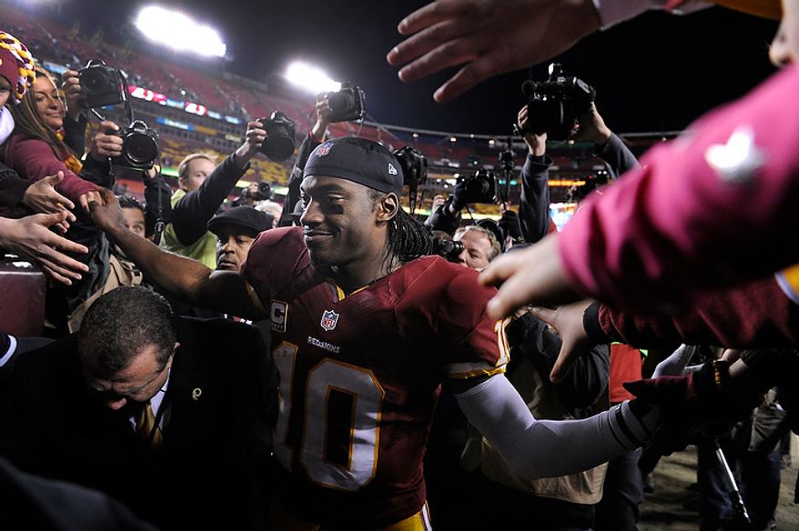 Washington Redskins quarterback Robert Griffin III (10) is greeted by fans as he leave the field after a loss in the NFC wild card game at FedEx Field, Landover, Md., Jan. 6, 2013. (Preston Keres/Special to The Washington Times)