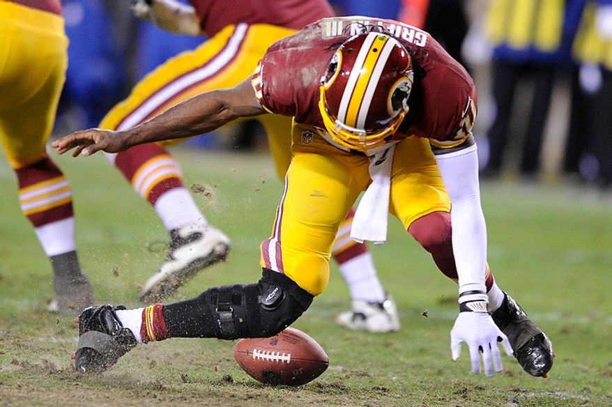 Washington Redskins quarterback Robert Griffin III (10) tries to pick up a fumbled snap in the fourth quarter and injures his leg in the NFC wild card game at FedEx Field, Landover, Md., Jan. 6, 2013. (Preston Keres/Special to The Washington Times)