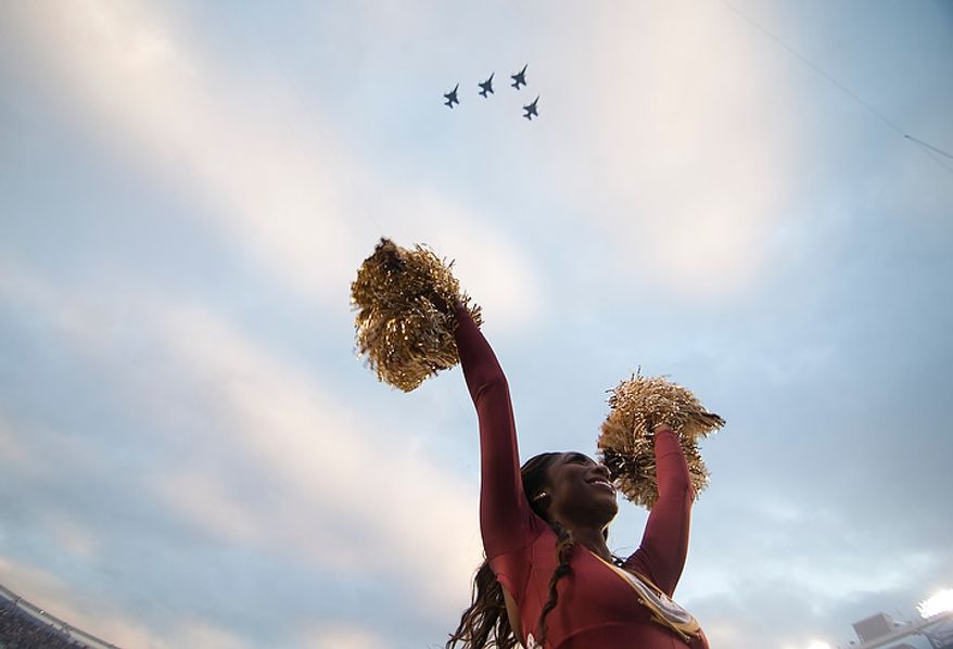 Washington Redskins cheerleader cheers as F-16's fly over before the start of the Washington Redskins against the Seattle Seahawks in the NFC wild card game at FedEx Field, Landover, Md., Sunday, January 6, 2013. (Craig Bisacre/The Washington Times)