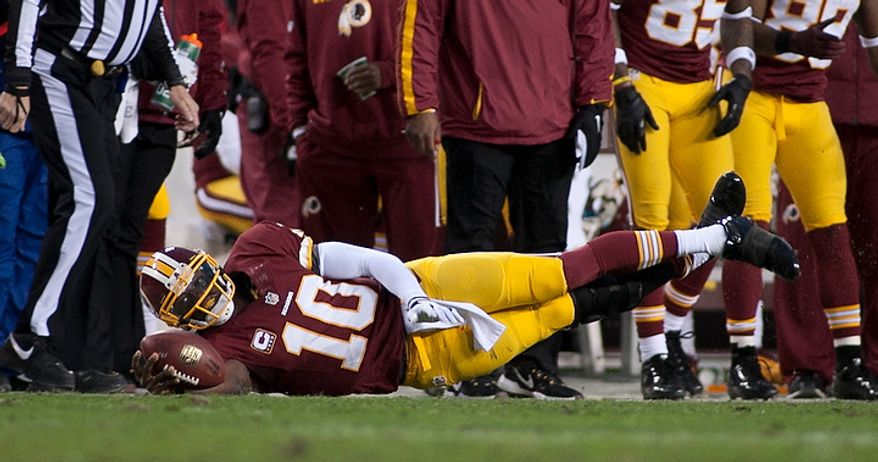 Washington Redskins quarterback Robert Griffin III (10) dives for a first down in the first half against the Seattle Seahawks in the NFC wild card game at FedEx Field, Landover, Md., Sunday, January 6, 2013. (Craig Bisacre/The Washington Times)