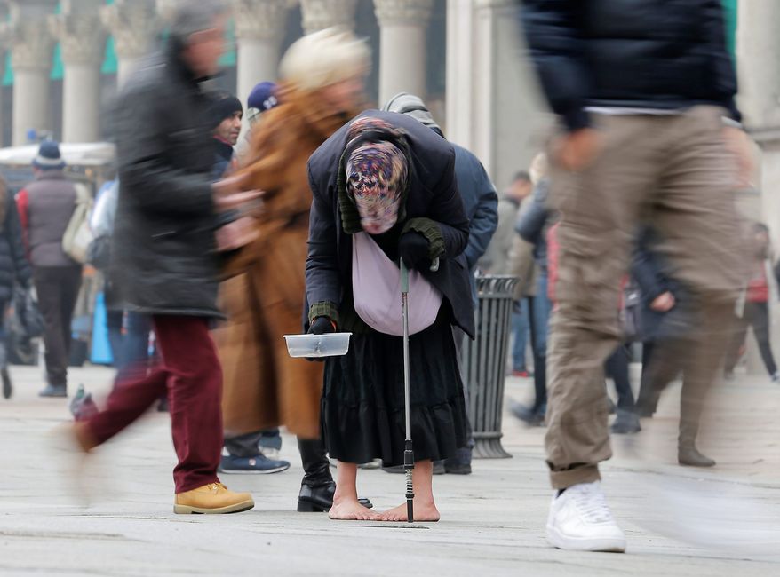 A woman begs for money amid passers-by in Milan, Italy, amid tough times. The number of jobless people in the 17 European Union countries that use the euro rose to 18.8 million, the highest figure since the single currency was founded in 1999. (Associated Press)
