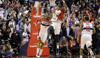 Washington Wizards guard Bradley Beal (3) and forward Trevor Ariza, center, celebrate Beal&#39;s game winning shot in the second half of an NBA basketball game against the Oklahoma City Thunder Monday, Jan. 7, 2013, in Washington. The Wizards won 101-99.(AP Photo/Alex Brandon)