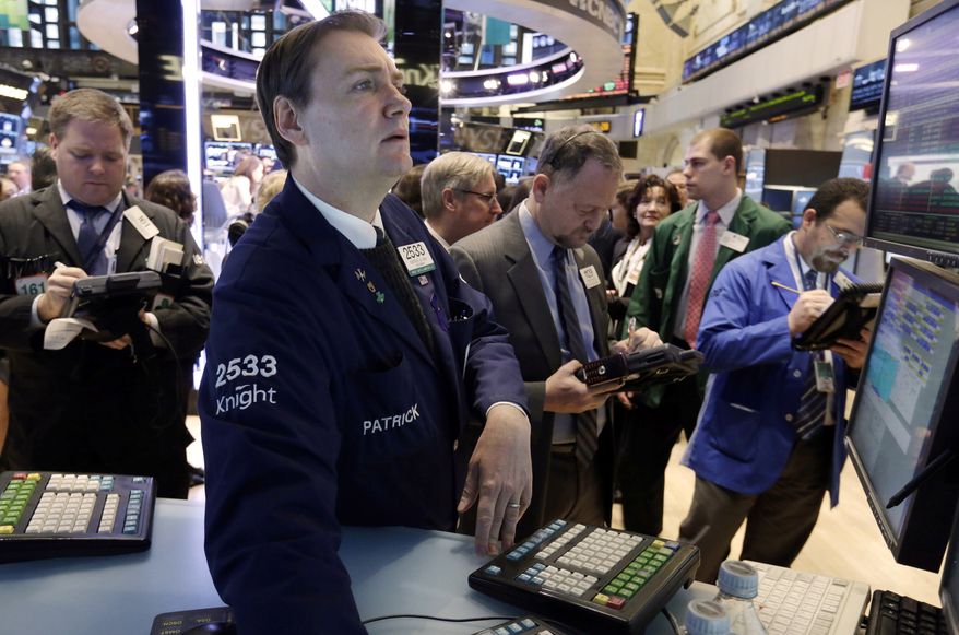 Specialist Patrick King (second from left) works on the floor of the New York Stock Exchange on Jan. 8, 2013. (Associated Press)