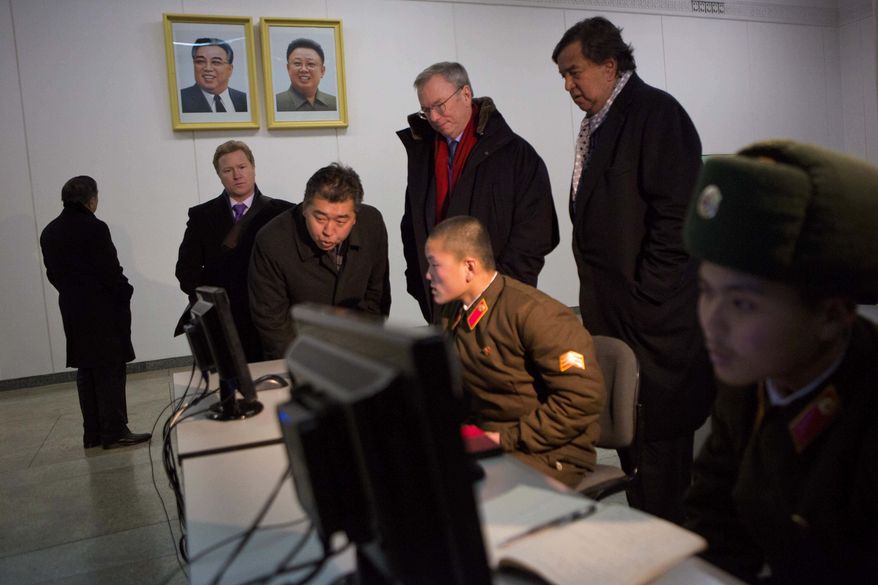 Executive Chairman of Google, Eric Schmidt, back row left, and former Governor of New Mexico Bill Richardson, back row right, look at North Korean soldiers working on computers at the Grand Peoples Study House in Pyongyang, North Korea on Wednesday, Jan. 9, 2013. (AP Photo/David Guttenfelder)