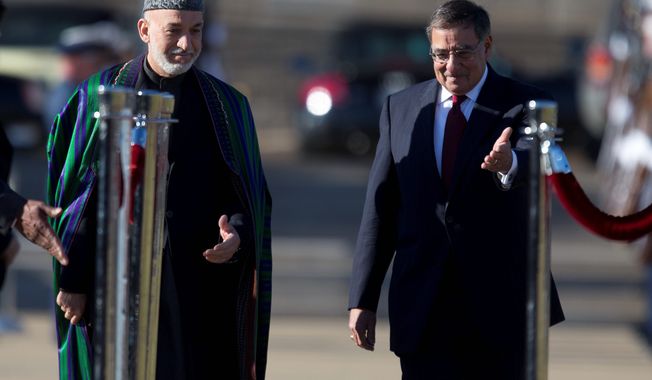 Defense Secretary Leon E. Panetta (right) motions Afghan President Hamid Karzai to the viewing stand during a full-honors arrival ceremony Thursday on the River Parade Field at the Pentagon. (Associated Press)