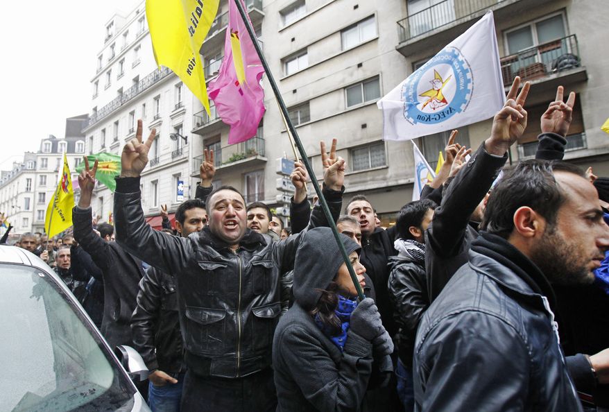 Kurds demonstrate on Thursday, Jan. 10, 2013, in front of a pro-Kurdish center in Paris where three Kurdish women were killed in what the French interior minister called an execution. (AP Photo/Remy de la Mauviniere)
