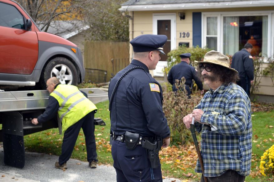 Television movie critic Gene Shalit (right) talks with a police officer after crashing his car into a house on Housatonic Street in Lenox, Mass., on Wednesday, Oct. 24, 2012. (AP Photo/The Berkshire Eagle, Ben Garver)