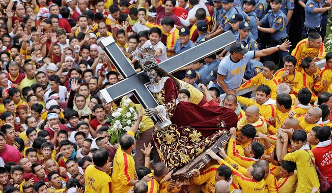 Catholic devotees jostle near the centuries-old image of the Black Nazarene on its feast day Wednesday in Manila. The Catholic Church no longer sways the masses on issues such as birth control as it once did. (Associated Press)