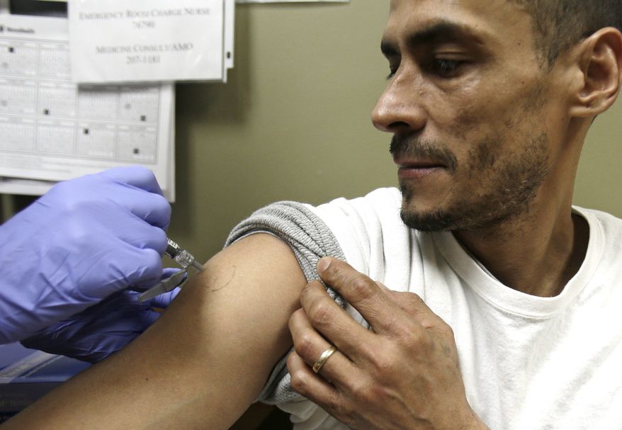 This Thursday, Jan. 10, 2013, photo shows Walter Vazquez, 43, getting a flu shot at MetroHealth in Cleveland. Ohio health authorities reported Friday, Jan. 11, 2013, that a child has died from flu complications, as the state's flu-associated hospitalizations continue to climb at much higher rates than the last two flu seasons. (AP Photo/Tony Dejak)