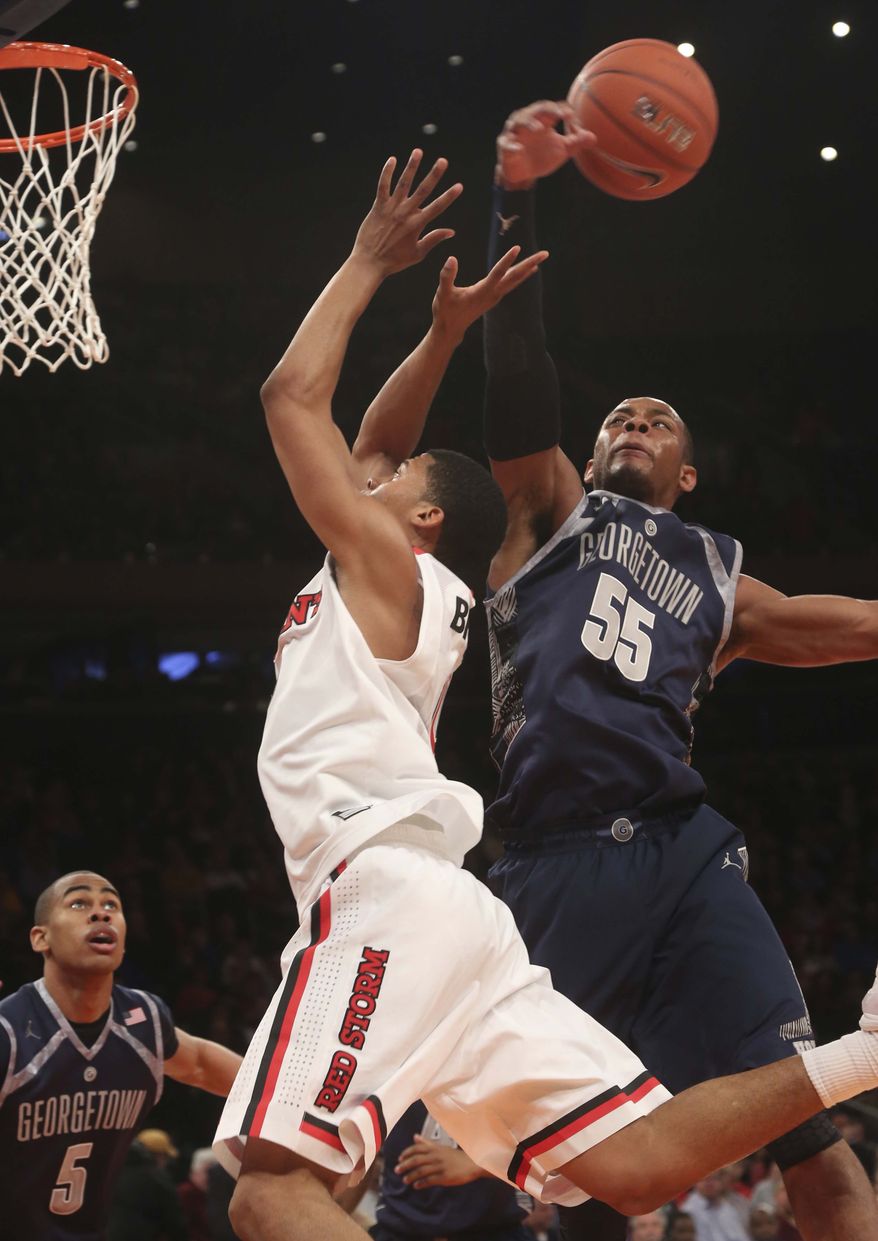 Georgetown's Jabril Trawick (55) blocks a shot by St. John's Jamal Branch during the second half of an NCAA college basketball game, Saturday, Jan. 12, 2013, at Madison Square Garden in New York. Georgetown won 67-51. (AP Photo/Mary Altaffer)