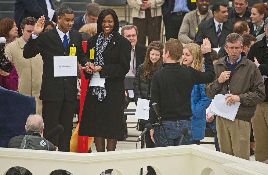Air Force Staff Sgt. Serpico D. Elliott and Army Spc. Delandra Rollins stand in Sunday for President Obama and first lady Michelle Obama at the rehearsals on the West Lawn of the Capitol. Meanwhile, window washers restore the gleam of the Newseum in anticipation of the festivities. (Associated Press)