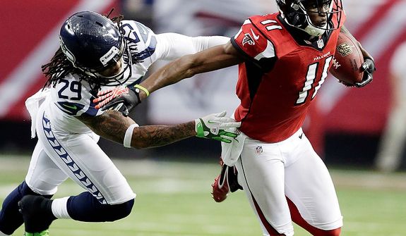 Atlanta Falcons wide receiver Julio Jones (11) tries to get away from Seattle Seahawks&#39; Earl Thomas (29) during the first half of an NFC divisional playoff NFL football game Sunday, Jan. 13, 2013, in Atlanta. (AP Photo/Dave Martin)