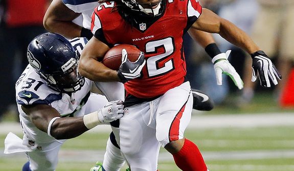 Atlanta Falcons running back Jacquizz Rodgers (32) works against Seattle Seahawks outside linebacker Malcolm Smith (53) and strong safety Kam Chancellor (31) during the second half of an NFC divisional playoff NFL football game Sunday, Jan. 13, 2013, in Atlanta. (AP Photo/John Bazemore)