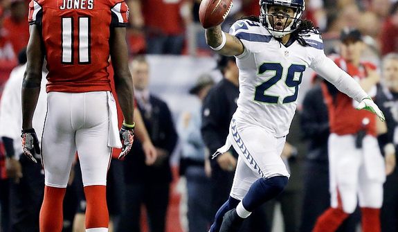 Seattle Seahawks free safety Earl Thomas (29) reacts to a turnover as Atlanta Falcons wide receiver Julio Jones (11) looks on during the second half of an NFC divisional playoff NFL football game Sunday, Jan. 13, 2013, in Atlanta. (AP Photo/David Goldman)