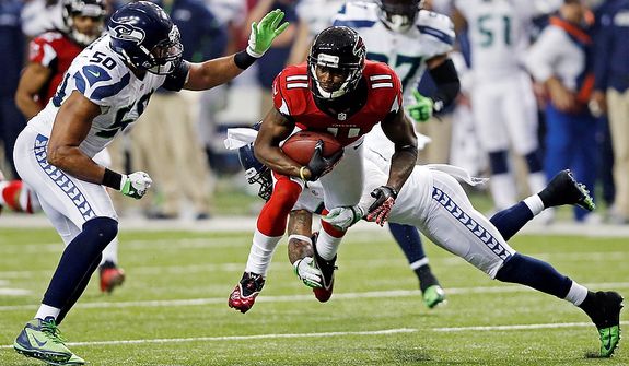 Atlanta Falcons wide receiver Julio Jones (11) works against Seattle Seahawks outside linebacker K.J. Wright (50) and free safety Earl Thomas (29) during the second half of an NFC divisional playoff NFL football game Sunday, Jan. 13, 2013, in Atlanta. (AP Photo/John Bazemore)
